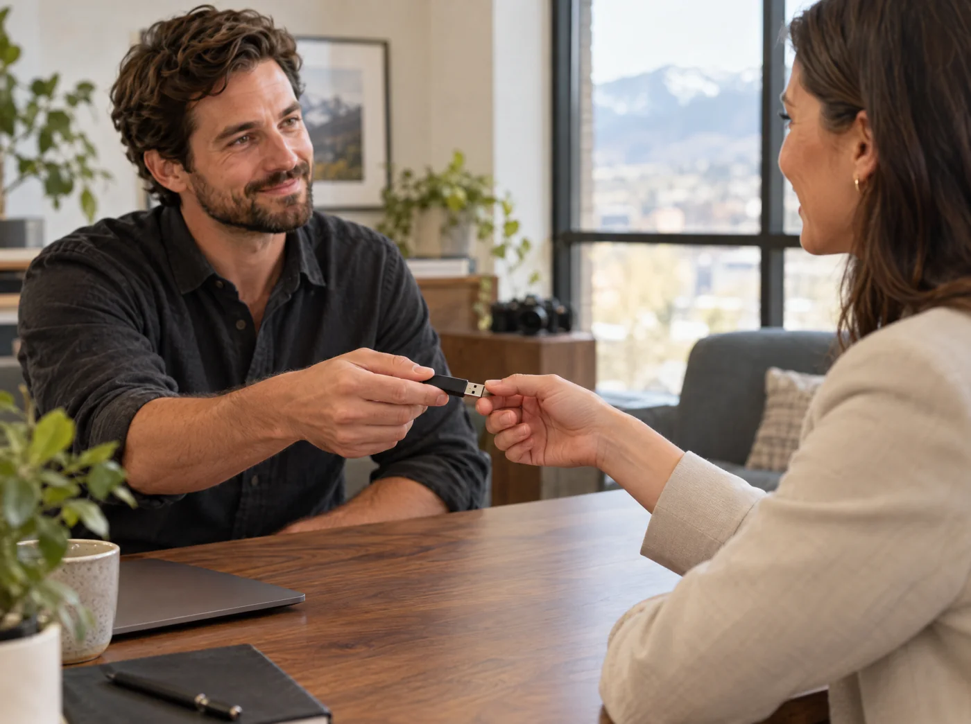 Creative professional handing project media to a client in an office